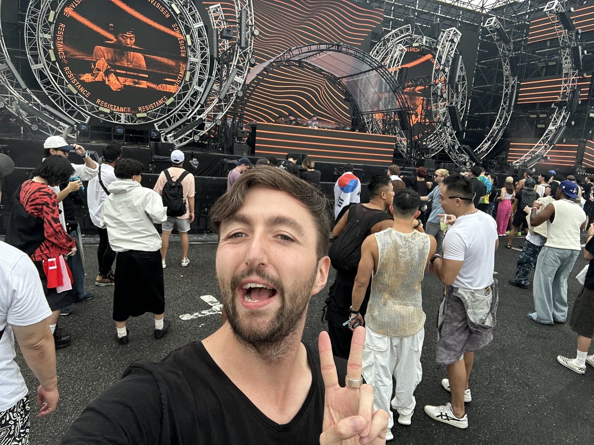 ステージの前で笑う Mate の Alex